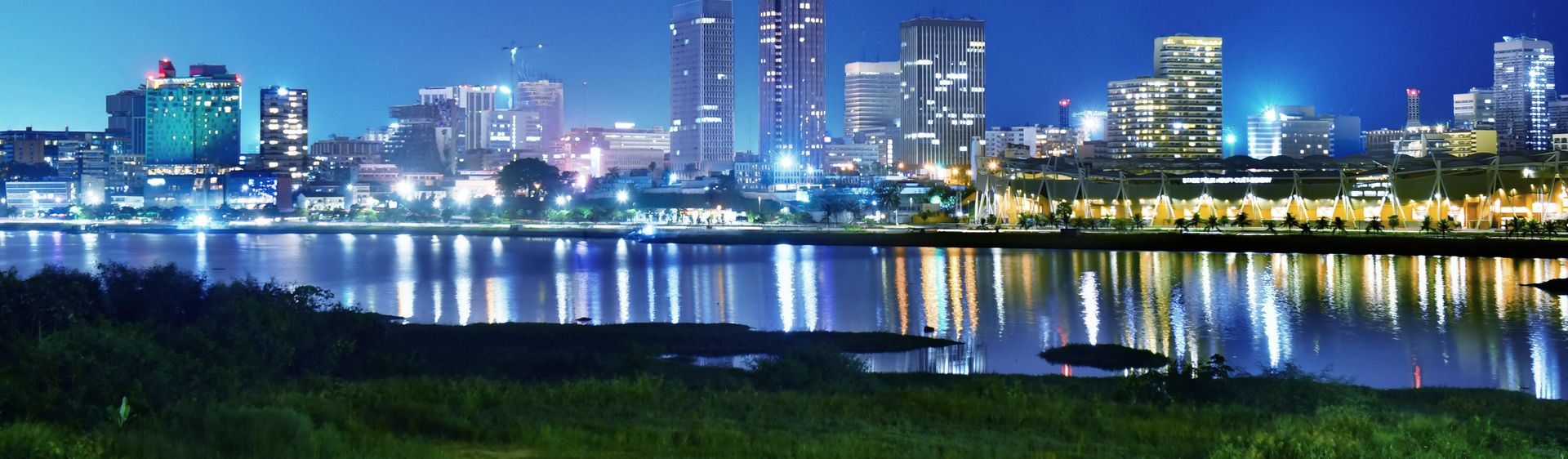 Le Plateau d’Abidjan et ses tours reflétés dans la lagune Ébrié, à la nuit tombée
